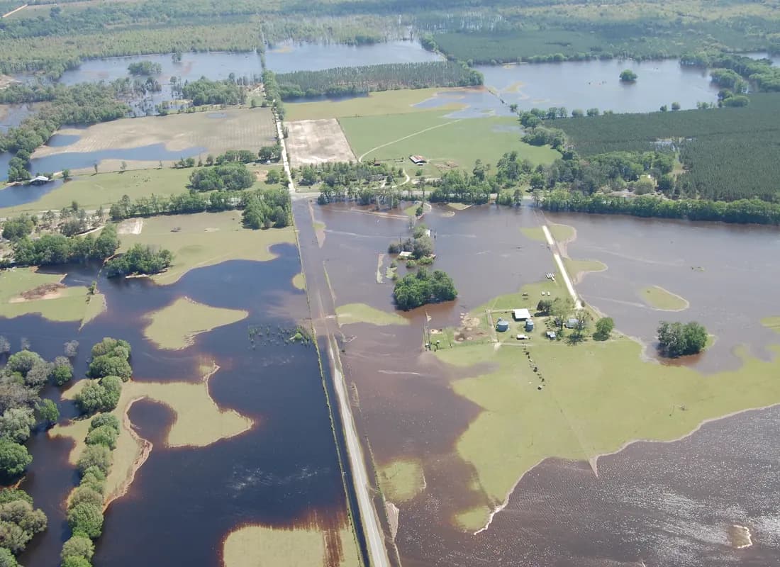 Vista aérea de una llanura inundada por el desborde del río Alapaha, con una carretera y una granja rodeadas de agua