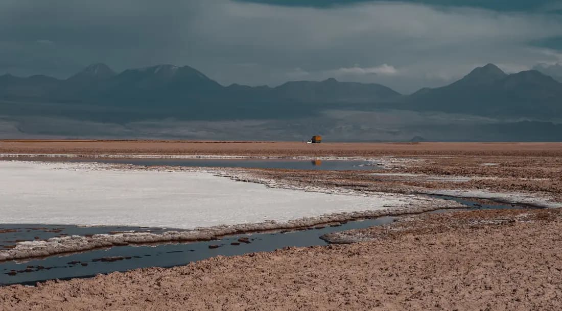 Salar de San Pedro de Atacama con una laguna de agua somera y la cordillera al fondo